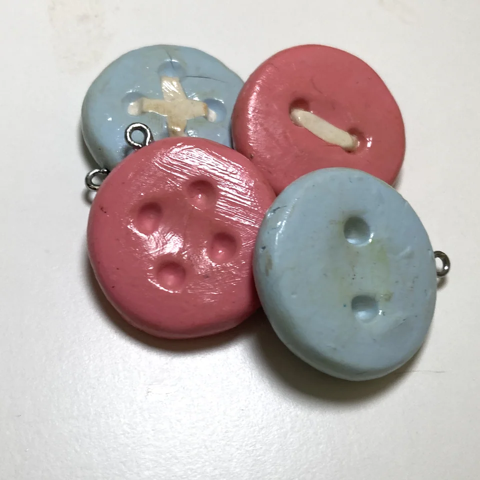 Pink and blue handmade button-shaped clay pieces